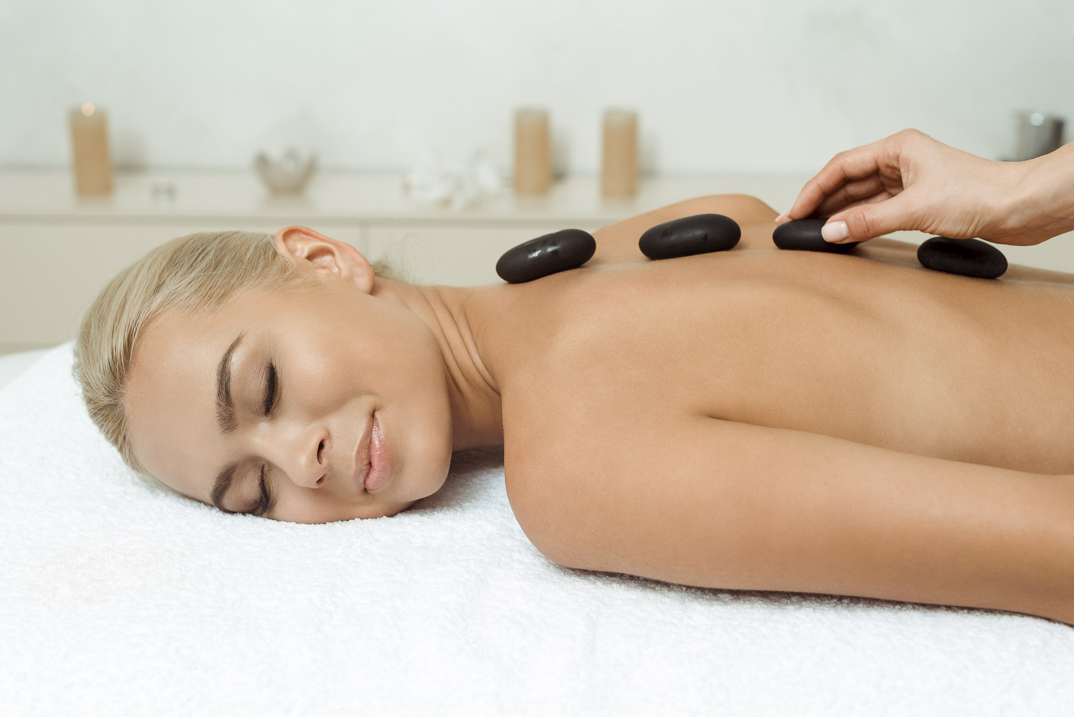 cropped view of masseur doing hot stone massage to attractive wo Hot-Stone-Massage bei Brigitte Konstroffer im Yoga Studio Merzig