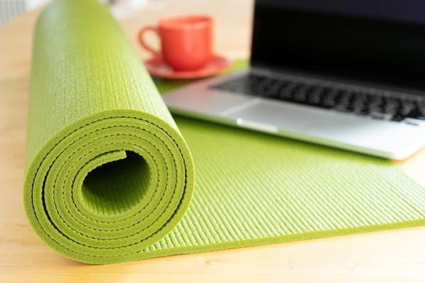 close up of green yoga mat on the table, sport and healthy and work out at office concept